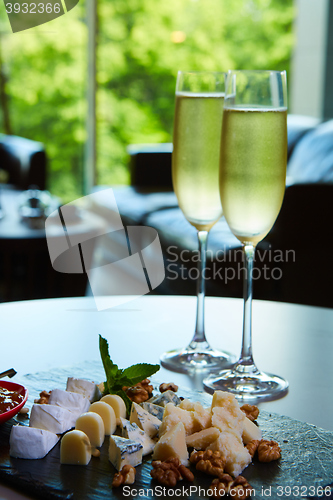 Image of two glasses of champagne with a tray cheese