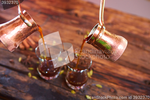 Image of To pour arabic coffee in cups on wooden background.