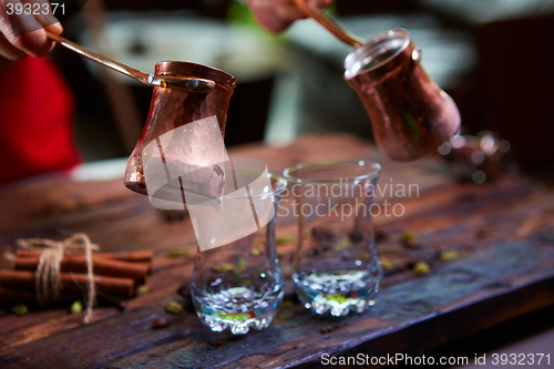 Image of To pour arabic coffee in cups on wooden background.