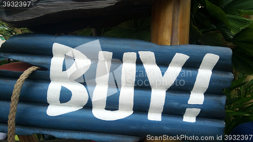 Image of Blue buy sign on wooden block 