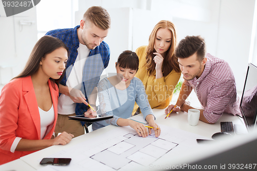 Image of creative team with blueprint working at office