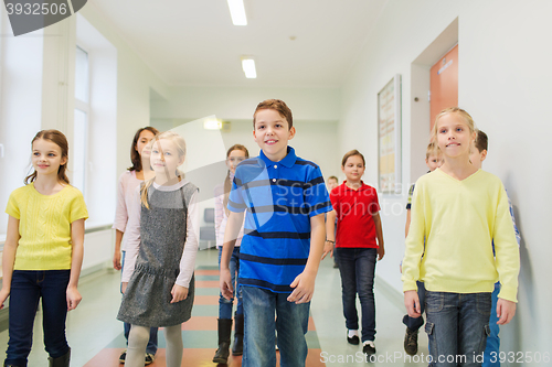 Image of group of smiling school kids walking in corridor