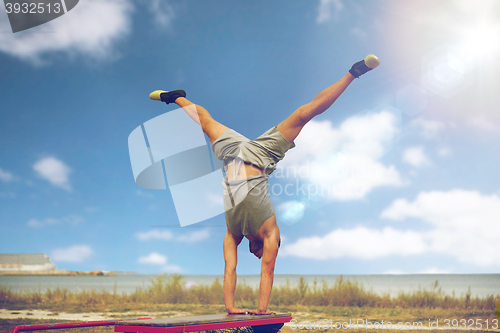 Image of young man exercising on bench outdoors