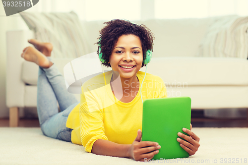 Image of happy african woman with tablet pc and headphones