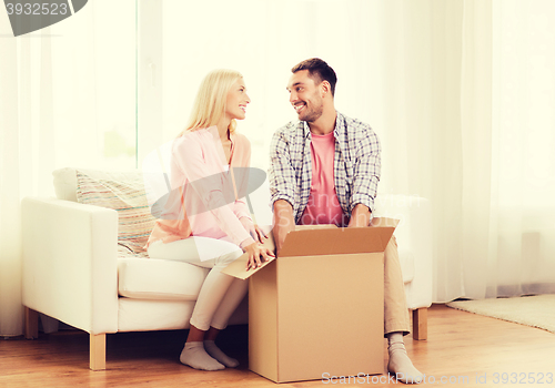 Image of happy couple with cardboard box or parcel at home