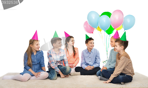 Image of happy smiling children in party hats on birthday