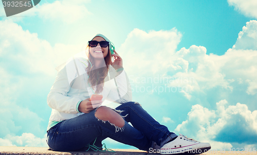 Image of happy young woman with smartphone and headphones