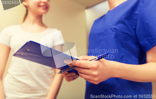 Image of close up of nurse with clipboard and pen with girl