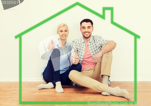 Image of happy couple showing thumbs up at new home