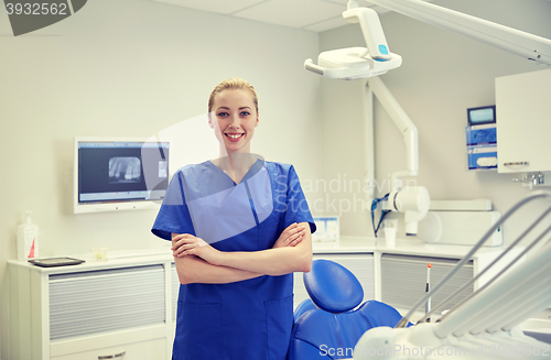 Image of happy young female dentist at dental clinic office