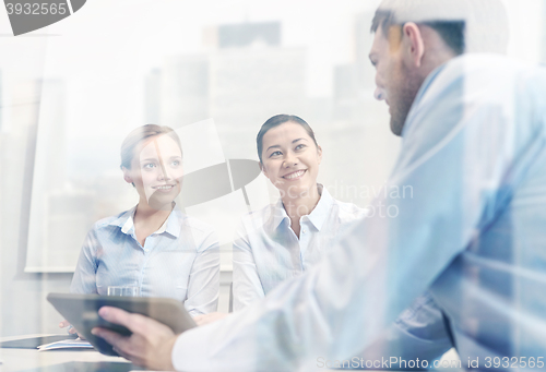 Image of smiling businesspeople with tablet pc in office