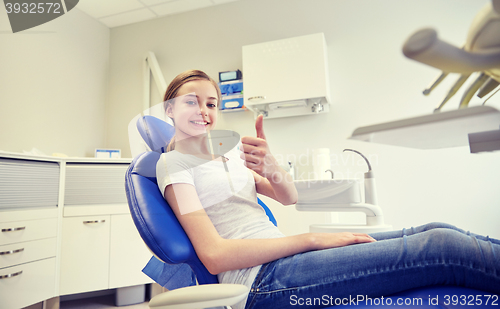 Image of happy patient girl showing thumbs up at clinic