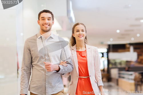 Image of happy young couple with shopping bags in mall