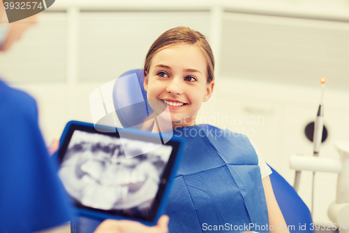 Image of dentist with x-ray on tablet pc and girl patient