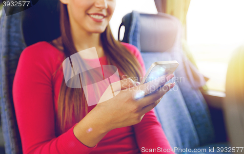Image of close up of woman in travel bus with smartphone