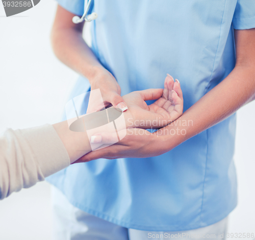 Image of nurse with patient measuring pulse