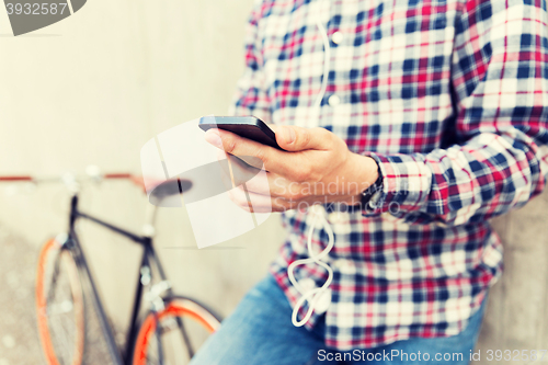 Image of close up of hipster man with smartphone and bike