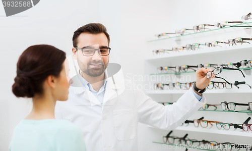 Image of woman and optician showing glasses at optics store