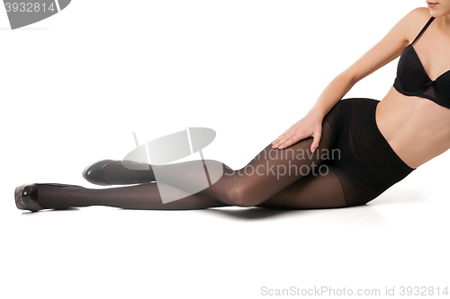 Image of Slim woman in bra and tights on floor