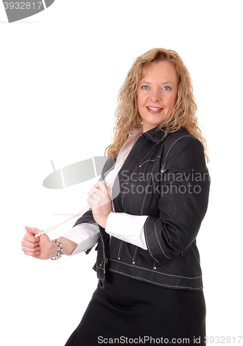 Image of Business woman playing with necklace.