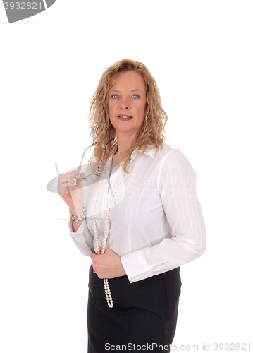 Image of Business woman standing holding her glasses.