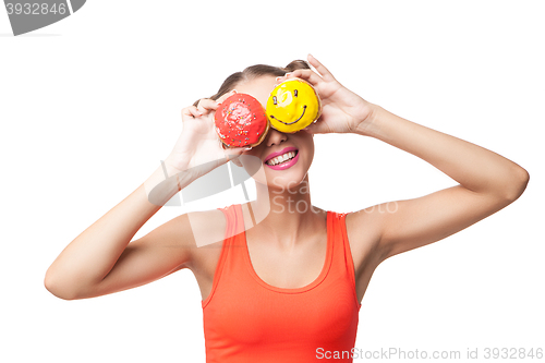 Image of Young smiling woman covering eyes with donuts