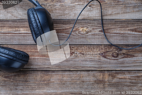 Image of Headphones over wooden table.