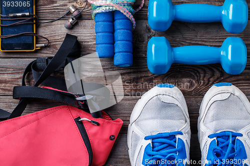 Image of Shoes and sports equipment on wooden floor, top view