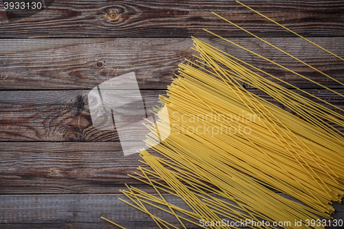 Image of Yellow long spaghetti on black background. Raw spaghetti.