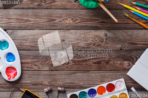 Image of Paper, watercolors, paint brush and some art stuff on wooden   table