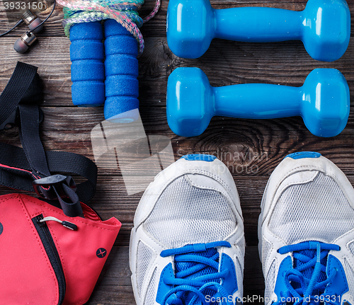 Image of Shoes and sports equipment on wooden floor, top view