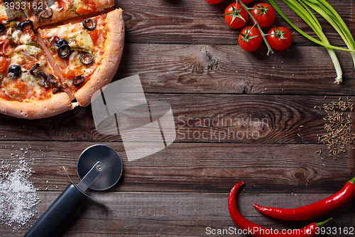 Image of Tasty pizza with ingridients on a wooden board.