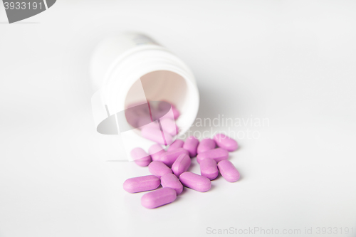 Image of Close-up of pink scattered pill from bottle