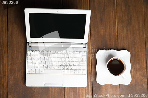 Image of Delicious cup of black coffee near laptop