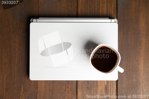 Image of Cup of coffee on laptop