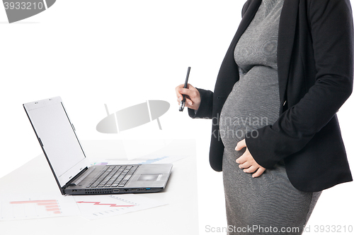 Image of Unrecognizable businesswoman waiting baby while working on laptop