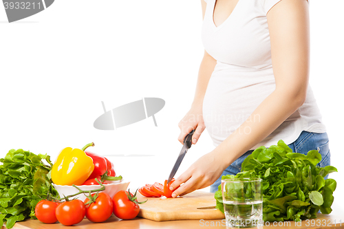 Image of Close-up of pregnant woman cutting tomato