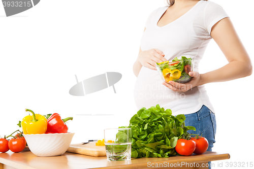 Image of Close-up of pregnant woman holding bowl with fresh vegetables