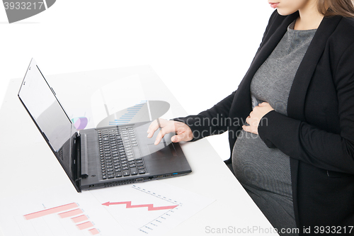 Image of Businesswoman waiting for baby while working on laptop