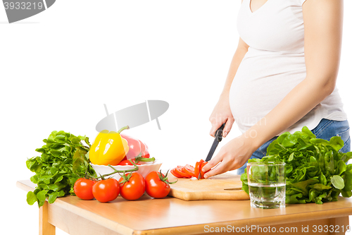 Image of Close-up of pregnant woman cutting tomato