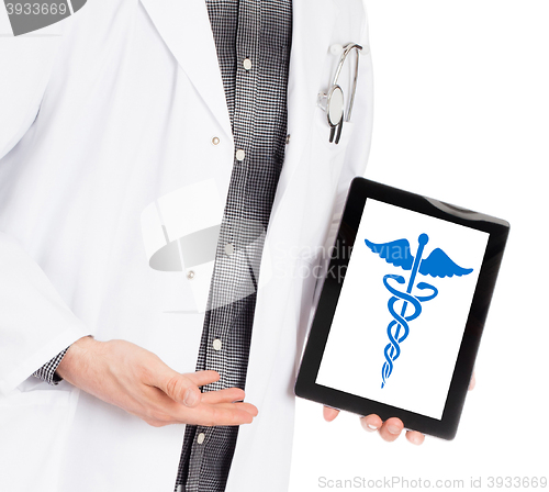 Image of Doctor holding tablet - Caduceus symbol