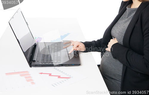 Image of Businesswoman waiting for baby while working on laptop