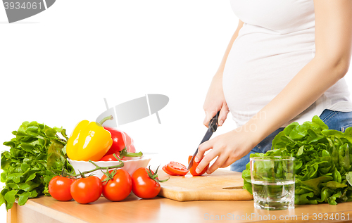 Image of Close-up of pregnant woman cutting tomato