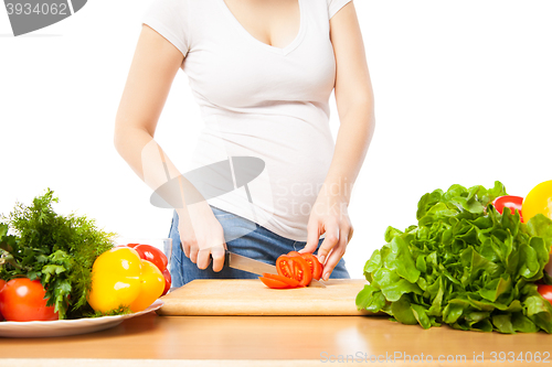 Image of Unrecognizable woman cutting tomato