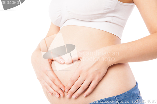 Image of Close-up of woman embracing her pregnant belly