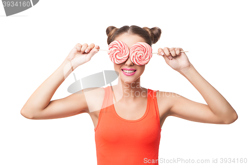 Image of Portrait of woman with buns holding lollipops on eyes