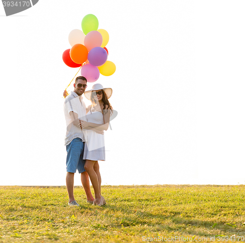 Image of smiling couple with air balloons outdoors