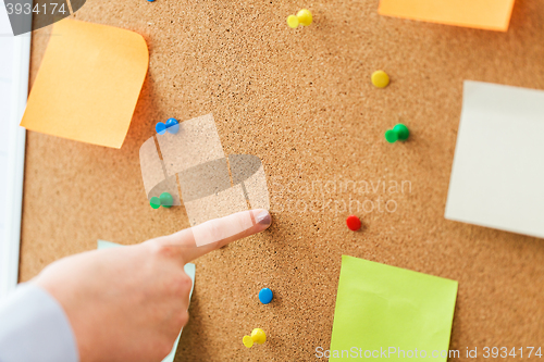 Image of hand pointing to cork board with stickers and pins