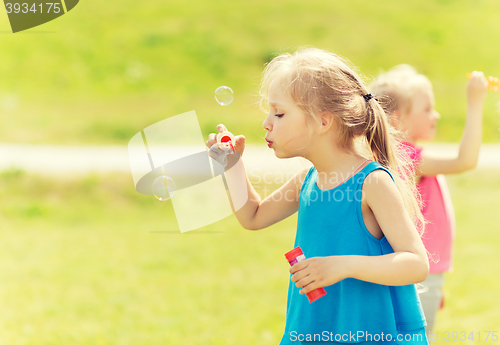 Image of group of kids blowing soap bubbles outdoors
