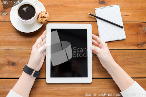 Image of close up of woman with tablet pc on wooden table